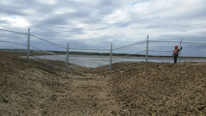 Galvanized chain link fence panels at an industrial site
